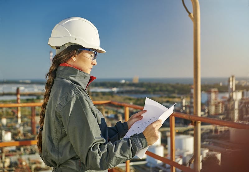 mujer técnica leyendo planos